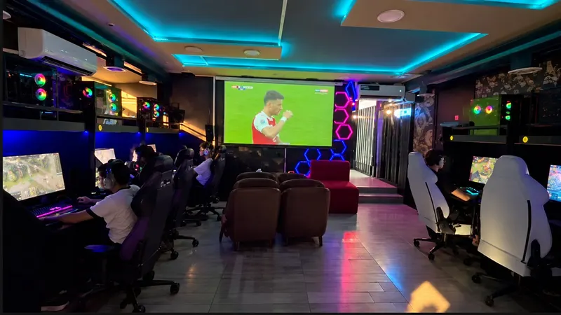 PC gaming hall with rows of gaming PCs, headsets and chairs